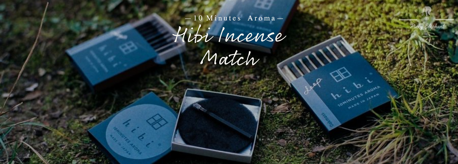 several cases of hibi incense matches in display on a grassland lawn, opened and showed the inside matches