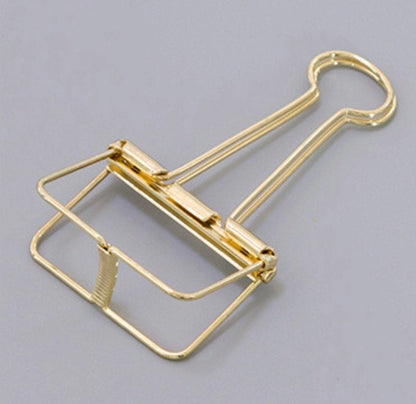 A golden skeleton paper clip in detail, in gray background