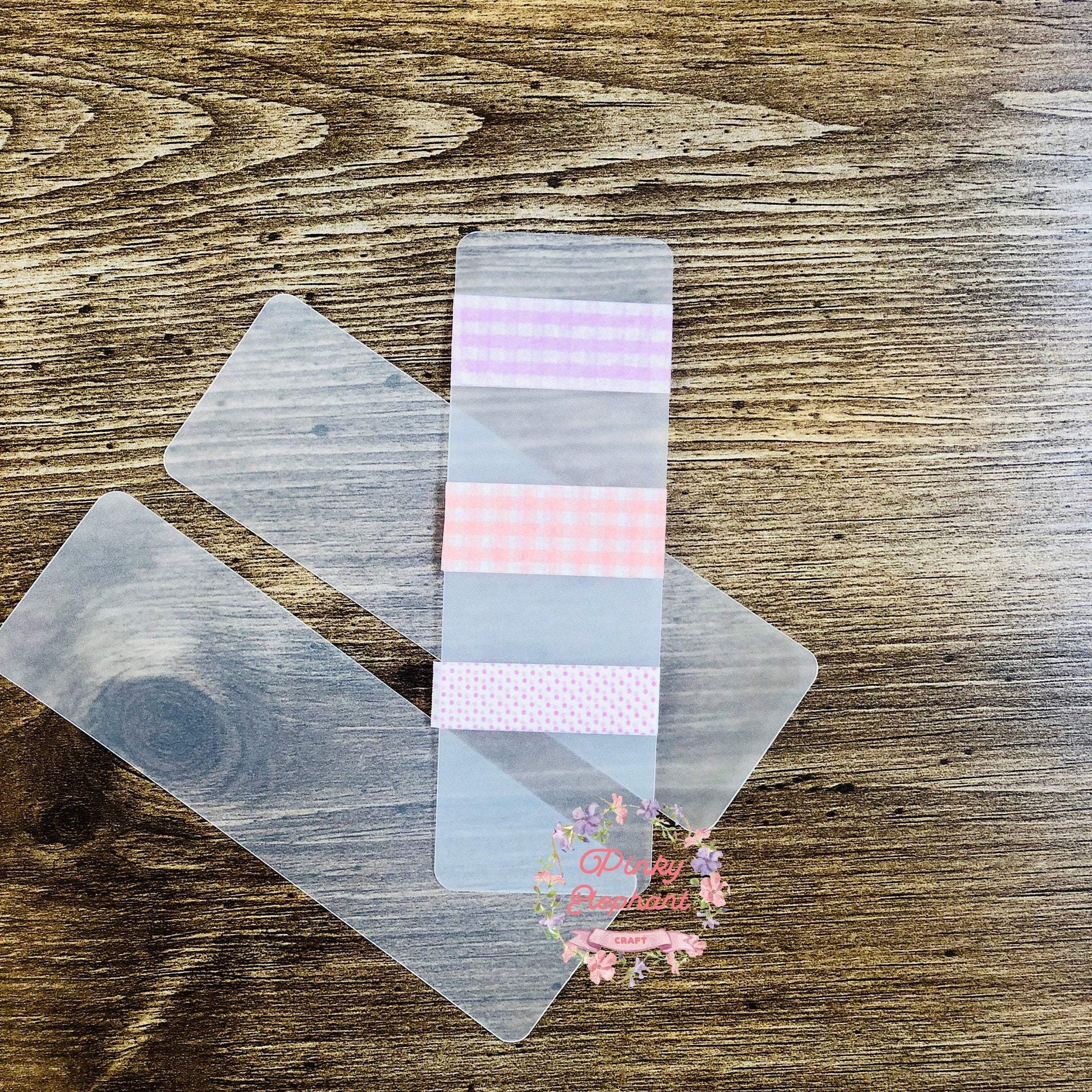 Top view of two clear washi tape cards and one sample card with three tapes on in a wooden background.